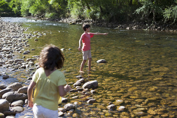 Niños remojándose los pies en el río