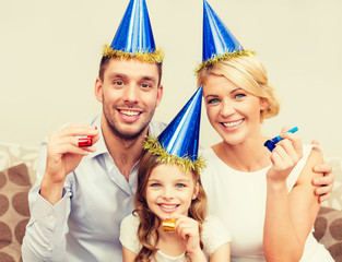 smiling family in blue hats blowing favor horns