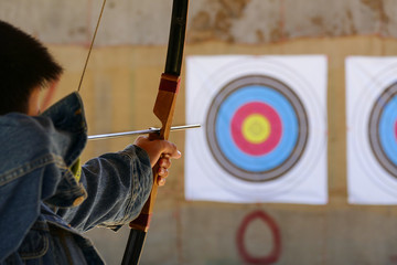 archer is aiming the archery at the target