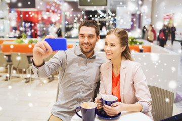 happy couple with smartphone taking selfie in mall