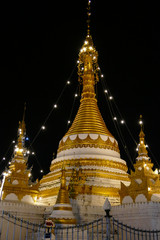 Fototapeta premium white and golden buddhist pagoda monument at night