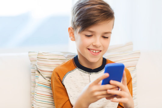 boy with smartphone texting or playing at home