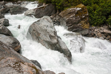 Obraz premium Colorful Rocks in White Water - New Zealand, Mt Aspiring National Park
