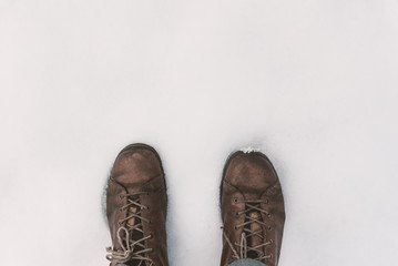 Mans shoe ond the snow, legs view