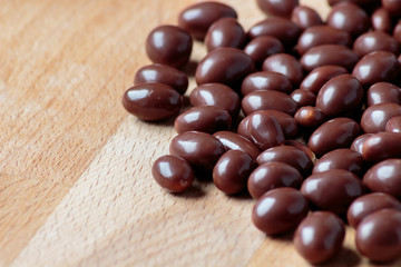 Chocolate dragee on wooden background