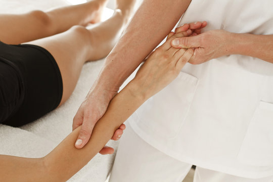 Terapeuta profesional dando masaje en un brazo, en la mu&ntilde;eca y en la mano. Vista supeior y de cerca