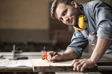 Carpenter measuring wooden board