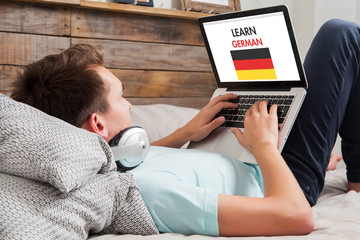 Man learning german at home. - obrazy, fototapety, plakaty