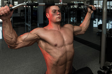 Fototapeta na wymiar Young Bodybuilder Doing Heavy Weight Exercise For Back