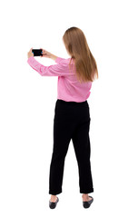 back view of standing young beautiful  woman  and using a mobile