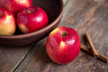 Red apples in a bowl with cinnamon 