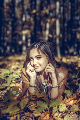 Portrait of happy lovely teenage girl lying on  autumn fallen le