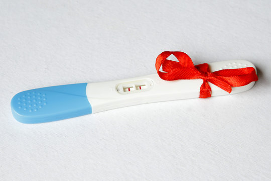 Pregnancy Test Positive Result On Clinic Table Present Red Ribbo