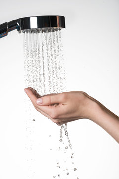 female hands under the stream of  water from shower