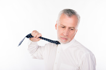 Old businessman choking himself with tie
