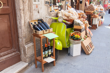 Tiny market exhibits goods on a Iconic italian scooter in Pitigl