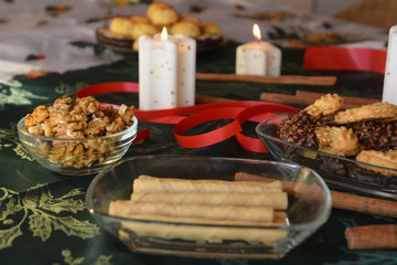 Lovely close up image of Christmas cookies on a decorated table with lighted candles