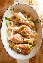 Raw chicken legs with onion and spices 