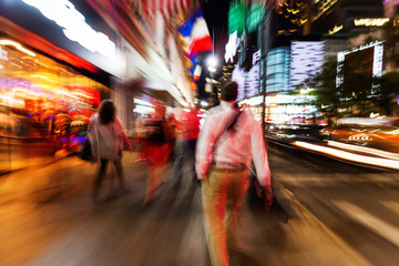 Bild mit kreativem Zoomeffekt von Menschen die nachts in Manhattan unterwegs sind