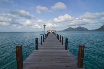 Obraz premium Long wooden pier heading toward Bohey Dulang Island in Sabah Borneo Malaysia.