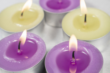 Obraz na płótnie Canvas Scented candles with lilac fragrance in front of others with green apple fragrance
