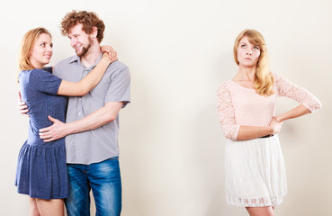 Abandoned woman with enamored couple