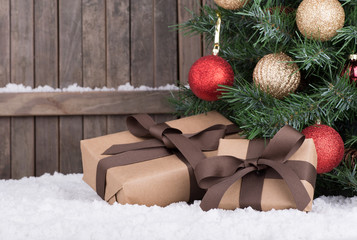 Gift Boxes by a Christmas Tree on a Wooden Background