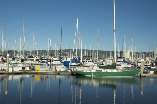 Green boat docked at marina on a clear sunny day