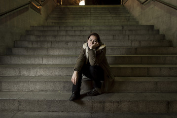 sad woman alone on street subway staircase suffering depression looking looking sick and helpless