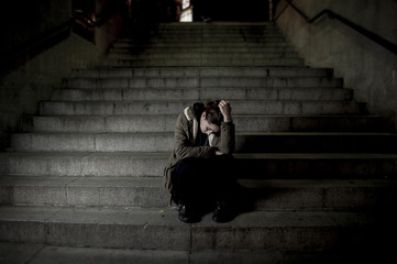 sad woman alone on street subway staircase suffering depression looking looking sick and helpless