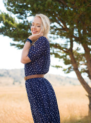 happy young woman with arms open under the trees