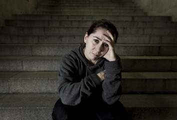 Obraz premium sad woman alone on street subway staircase suffering depression looking looking sick and helpless