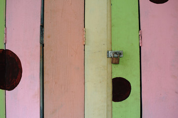 Old Rusty Padlock On Colorful Wooden Door