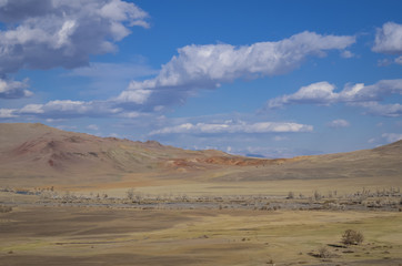 Fototapeta na wymiar Hills on Mars. Sunny summer day, the hills in the desert land, mountains in the distance