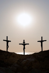 Three crosses on a hill over bright sky