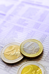Euro money in office -  euro coins and bursa news in the newspaper - business and finance