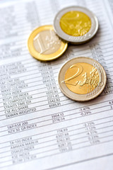 Euro money in office -  euro coins and bursa news in the newspaper - business and finance
