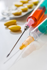Different pills in blister and syringe with needle - health care system
