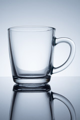 Empty glass cup with reflection on a table on a black background