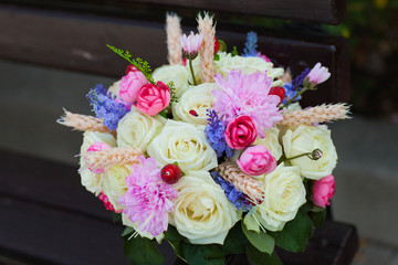 Wedding bouquet with roses on a wooden bench