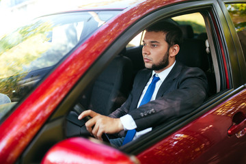 Handsome young man driving a car.