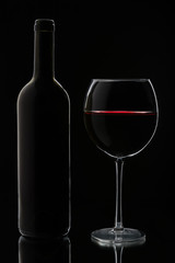 Glass of red wine and bottle
