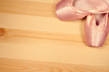 Pointe shoes on a wooden background with copyspace