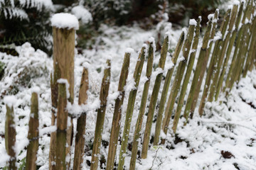 Top view at fresh xmas snow covered paling fence in winter landscape. Frosty nature scene in garden park, perfect for christmas, gardening blog, product and magazines