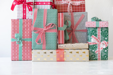 Horizontal view of christmas presents on white table.