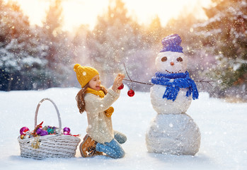 girl playing with a snowman