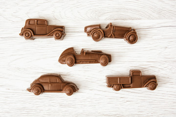 Set of chocolate car figures on wooden background