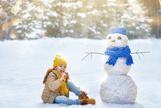girl playing with a snowman