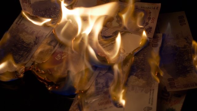 Burning 100 argentinian pesos bills