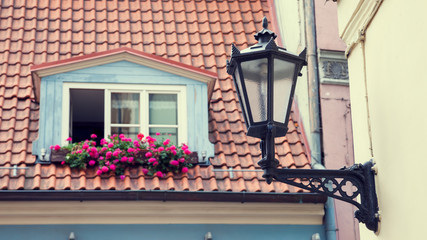 Vintage street lamp on wall and window in garret roof on backgro